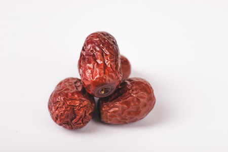Bowl of Jujube or dried unabi fruit, chinese red date isolated in white backgroundの写真素材