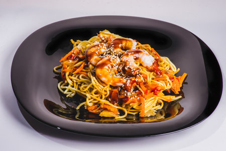 A bowl of delicious spicy asian shrimp noodle soup with mushroom, red pepper, snow peas and scallions.の写真素材