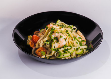 Tagliatelle pasta with fried shrimps, cheese Parmesan, parsley and zucchini ribbons, handmade dishの写真素材