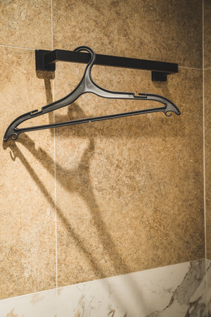 Wooden rack with hangers near gray wallの写真素材