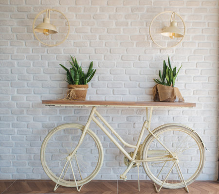 Pink vintage bike with basket full of flowers next to an old cyan building in Spainの写真素材