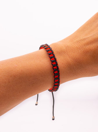 an adult man in a white dress shirt holds a wooden rosary in his hands, without a face close-upの写真素材