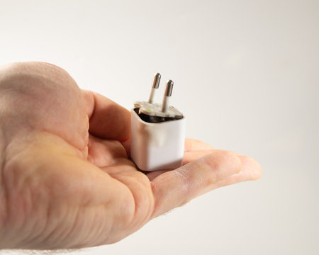 faulty cell battery charger, short circuit, charged. danger of domestic accident with cell phoneの写真素材