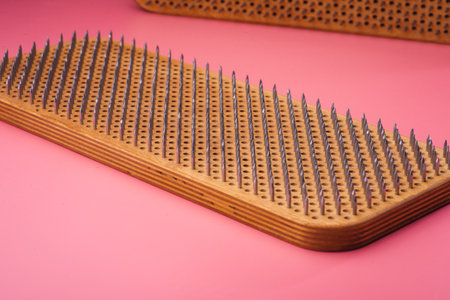 Woman's feet stand on a board with nails