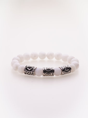 A charming double bracelet in shades of pink, made from natural stone and set against a gray background. The heart charm stands out in this close-up top viewの写真素材