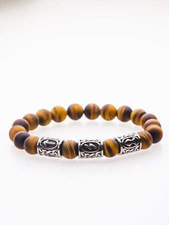 A charming double bracelet in shades of pink, made from natural stone and set against a gray background. The heart charm stands out in this close-up top viewの写真素材