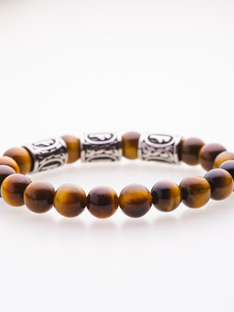 A charming double bracelet in shades of pink, made from natural stone and set against a gray background. The heart charm stands out in this close-up top viewの写真素材