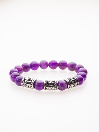 A charming double bracelet in shades of pink, made from natural stone and set against a gray background. The heart charm stands out in this close-up top viewの写真素材