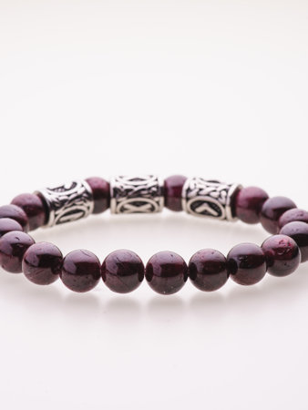 A charming double bracelet in shades of pink, made from natural stone and set against a gray background. The heart charm with cubic zirconia stands out in this close-up top viewの写真素材