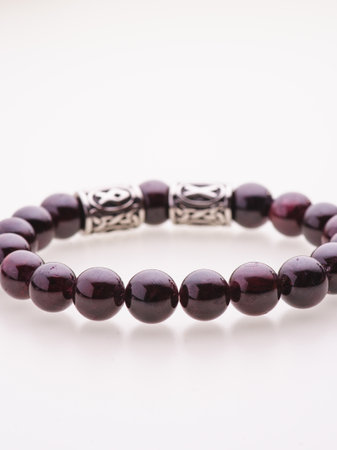 A charming double bracelet in shades of pink, made from natural stone and set against a gray background. The heart charm stands out in this close-up top viewの写真素材