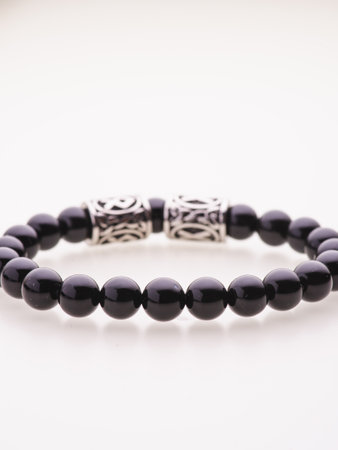 A charming double bracelet in shades of pink, made from natural stone and set against a gray background. The heart charm stands out in this close-up top viewの写真素材