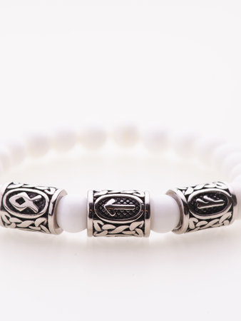 A charming double bracelet in shades of pink, made from natural stone and set against a gray background. The heart charm with cubic zirconia stands out in this close-up top viewの写真素材