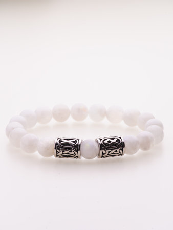 A charming double bracelet in shades of pink, made from natural stone and set against a gray background. The heart charm stands out in this close-up top viewの写真素材