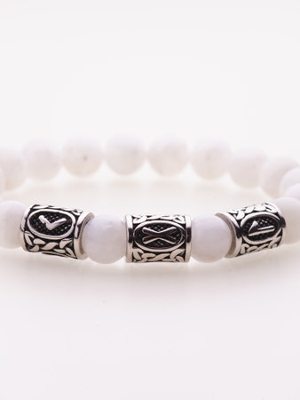 A charming double bracelet in shades of pink, made from natural stone and set against a gray background. The heart charm stands out in this close-up top viewの写真素材