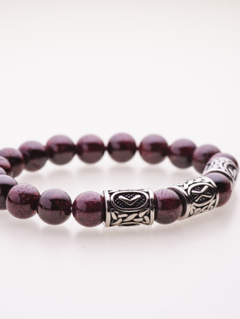 A charming double bracelet in shades of pink, made from natural stone and set against a gray background. The heart charm stands out in this close-up top viewの写真素材