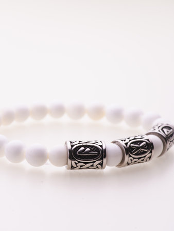 A charming double bracelet in shades of pink, made from natural stone and set against a gray background. The heart charm with cubic zirconia stands out in this close-up top viewの写真素材