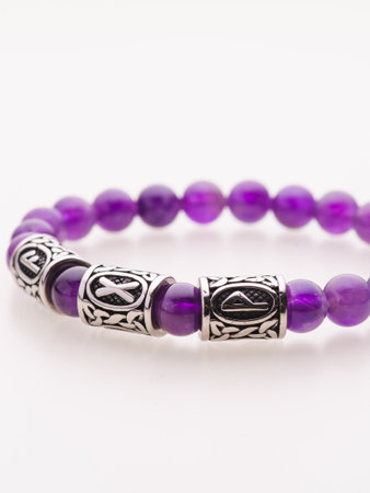 A charming double bracelet in shades of pink, made from natural stone and set against a gray background. The heart charm stands out in this close-up top viewの写真素材