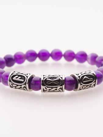 A charming double bracelet in shades of pink, made from natural stone and set against a gray background. The heart charm with cubic zirconia stands out in this close-up top viewの写真素材