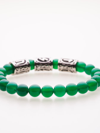 A charming double bracelet in shades of pink, made from natural stone and set against a gray background. The heart charm stands out in this close-up top viewの写真素材