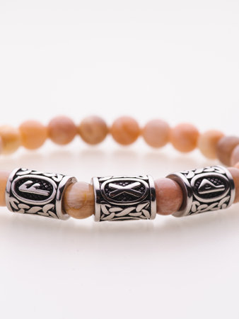 A charming double bracelet in shades of pink, made from natural stone and set against a gray background. The heart charm with cubic zirconia stands out in this close-up top viewの写真素材