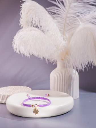 Purple bracelet with gold charm, isolated on white background.の写真素材