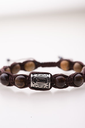 A charming double bracelet in shades of pink, made from natural stone and set against a gray background. The heart charm stands out in this close-up top viewの写真素材