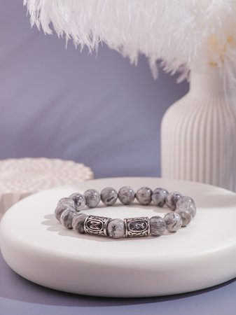 Gray and silver bracelet on a white surface.の写真素材