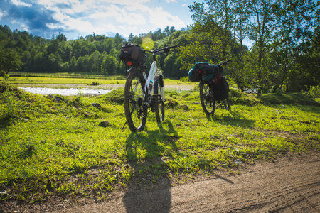 Cyclist with a saddle bag near a lake. Traveler on bicycle on sunny dayの写真素材