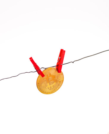 Isolated photo of a bitcoin coin clipped to a clothesline on a white background.