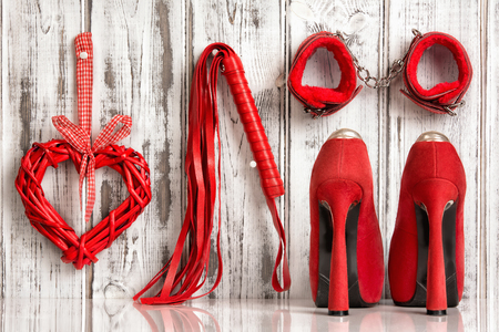 red shoes lash heart handcuffs on a wooden backgroundの写真素材