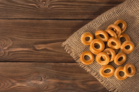 Small dry bagels on wooden table, top view.の写真素材