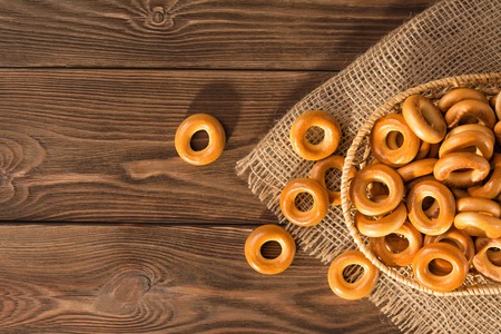 Small dry bagels on wooden table, top view.の写真素材