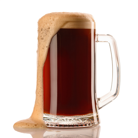 Mug of frosty dark beer with foam isolated on a white backgroundの写真素材