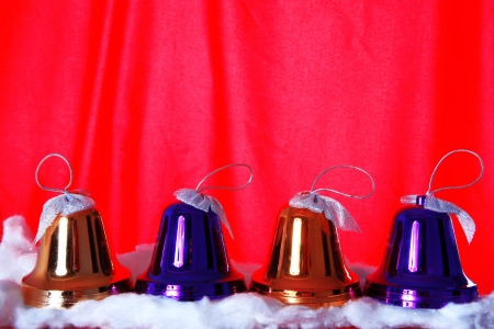 red christmas bells against red backgroundの写真素材