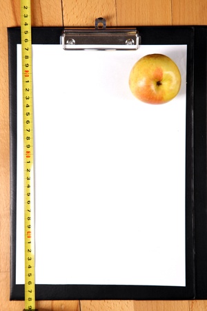 diet plan - blank clipboard with a measuring tape, apple and copy space ( focus on apple)の写真素材