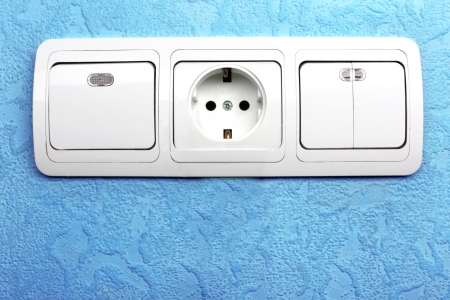 Electrical switch and plug in blue wall
