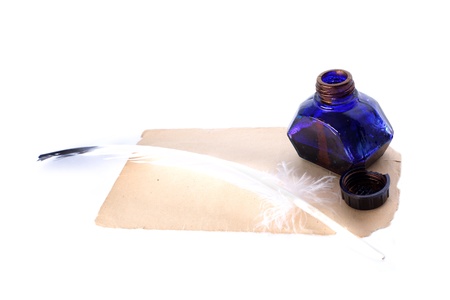 Antique pen and inkwell at old paper isolated on whiteの写真素材