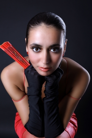 alone in the dark - woman in red dress and fanの写真素材