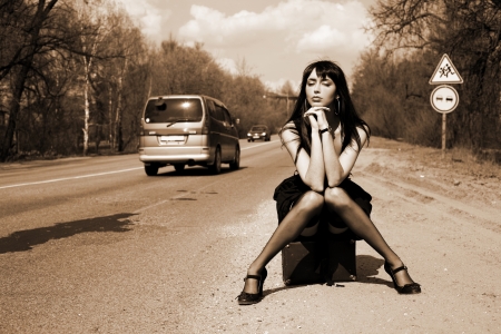 girl in the road sit atop vintage suitcaseの写真素材