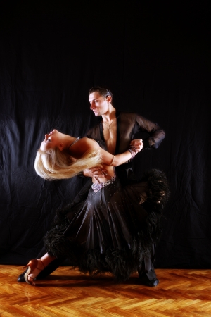 dancers in ballroom against black backgroundの写真素材