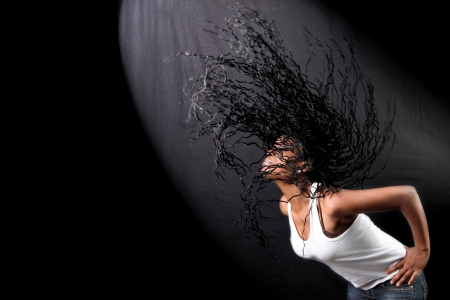 wind - lovely young afro-american woman with long flapping hairs against black background