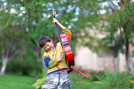Music student playing the guitar and sing outdoorsの写真素材