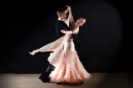 Latino dancers in ballroom against on blackの写真素材