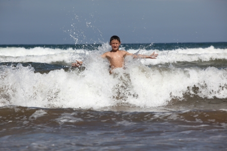 boy play with ocean wavesの写真素材
