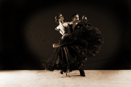 Latino dancers in ballroom against on black の写真素材