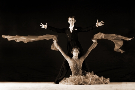 Latino dancers in ballroom against on black の写真素材