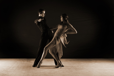 dancers in ballroom against on black backgroundの写真素材