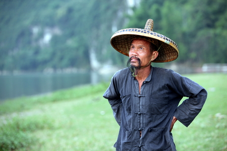 GUANGXI - JUNE 18: Chinese man in old hat in Guangxi region, traditional type of man face in China, June 18, 2012 in Guangxi, China. The average life expectancy among Chinese men is 72 yearsのeditorial素材