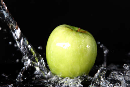 Green apples in water splashの写真素材