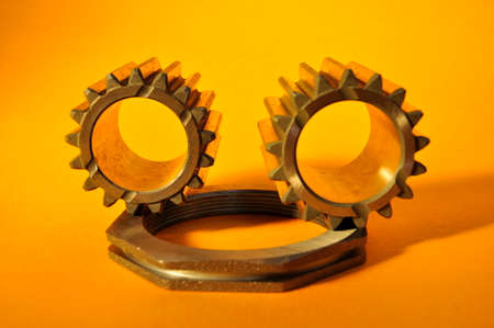 Metallic cogwheels on a yellow background.の写真素材